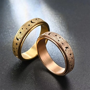 Close-up of rotatable stardust rings with hollow moon and star patterns in gold finish