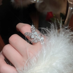 Macro detail of silver double butterfly ring with sparkling cubic zirconia on feathers
