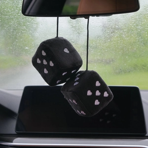 Close-up of black plush dice car hanging ornament with pink embroidered hearts