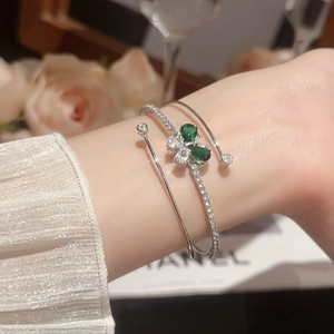 Dettaglio del bracciale a farfalla in zircone lucido con gemme verdi a forma di pera