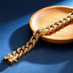 Dettaglio ravvicinato di un bracciale a catena cubana placcato oro con zirconi scintillanti