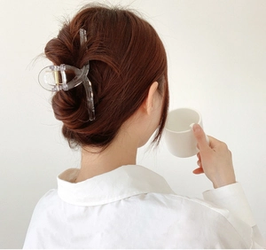 Detailed view of large transparent square hair claw clip on dark brown updo hair style