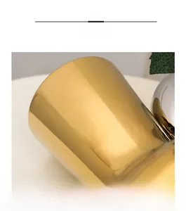 Detail view of modern gold electroplated ceramic vase with glossy mirror finish texture