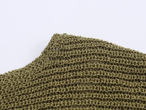 Close-up of olive green knit fabric showing detailed hollow weave honeycomb texture