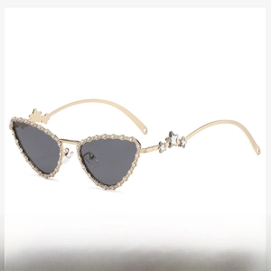 Close-up of cat-eye sunglasses with crystal-encrusted frames and metal star temple detail