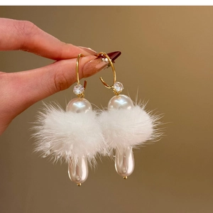 Detail of C-shape earring with white pompom, pearls and sparkling zircon accents