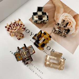 Top view of assorted acetate claw clips in checkerboard, tortoiseshell, and marble patterns