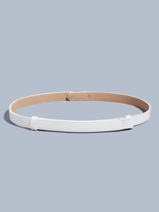 Macro detail of white cross-grain leather belt showing silver studs and inner brown lining