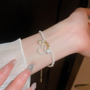 Bracelet perles style français avec pendentif gourde en zircon sur poignet au style luxe élégant