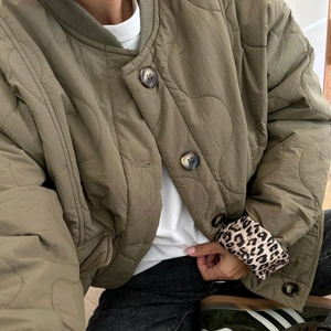 Army green quilted jacket with button closure and leopard print lining on the cuffs