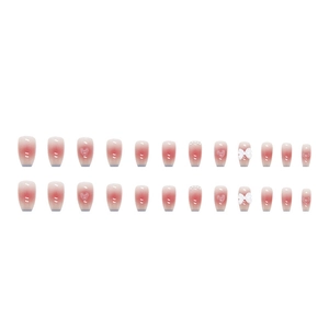 Detail of ombre pink coffin press-on nails with 3D hearts, bows and pearl accents
