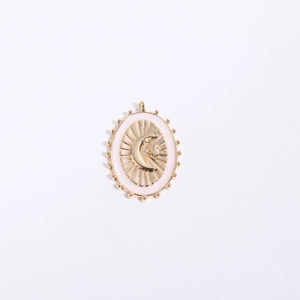 Oval gold plated pendant featuring pink enamel with moon and starburst embossed motifs