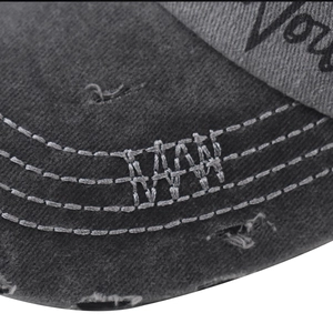 Détail d'une casquette gris foncé délavée avec broderie NY et bord de visière usé