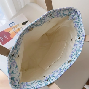 Detail view of floral cotton tote bag showing inner pocket and magnetic closure