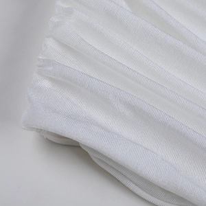 White pleated crop top fabric detail showing fine texture and elastic knit design.