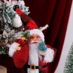 Close-up of plush Santa doll holding a gift bag and a miniature Christmas tree decoration