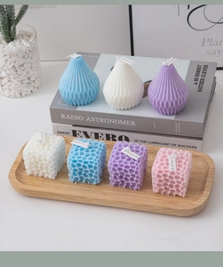 Close-up of geometric bubble and teardrop scented candles in pastel blue and pink