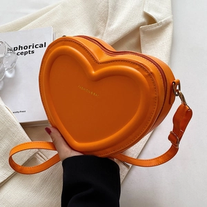 Dettaglio della borsa a tracolla arancione a forma di cuore in pelle PU goffrata