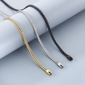 Detailed view of woven Chopin chains in gold, silver, and black stainless steel
