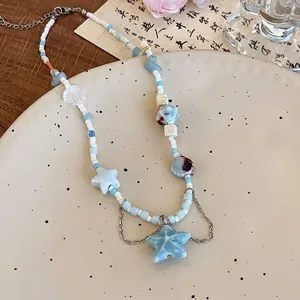 Détails d'un collier de perles de plage avec pendentif étoile de mer bleue et coquillages