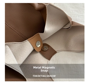 Close-up of brown pebbled leather tote bag with magnetic snap button and fine stitching