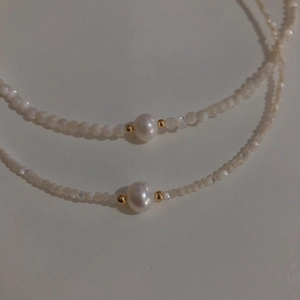 Detail of freshwater pearl necklace with cat-eye stone and 14K gold accents