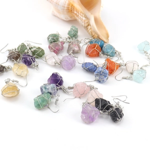 Macro view of handmade wire-wrapped natural raw crystal stone earrings in various colors