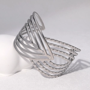 Dettaglio del bracciale rigido largo in acciaio argentato multistrato con linee a forma di V