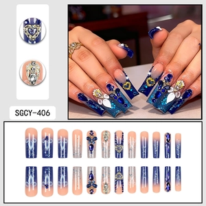 Starry gradient press-on nails with blue gems, pearls and gold heart charms in long coffin shape