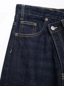 Détail du jean bleu indigo foncé avec une taille asymétrique double originale et boutons
