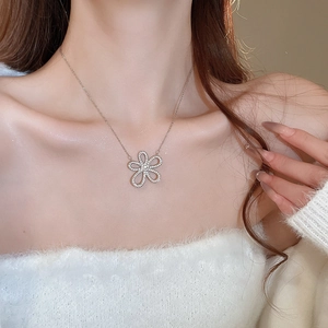 Close-up of sparkling flower pendant necklace with silver finish on model neck