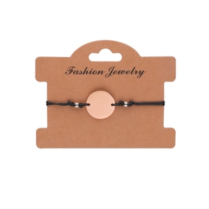 Minimalist adjustable black woven cord bracelet with a polished rose gold circular pendant