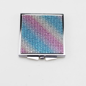 Detail of a square folding makeup mirror with sparkling colorful rhinestones on metal