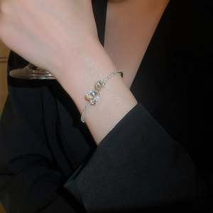 Detailed close-up of double heart zircon silver bracelet with pavé-set diamonds on wrist