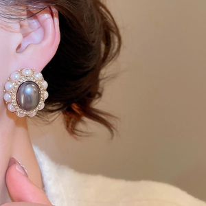Close-up of vintage baroque style oval pearl earring with rhinestones on a golden base