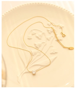 Detail of 18K gold plated necklace with a sparkling white gemstone on a vintage plate