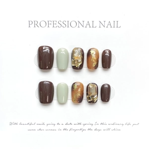 Handmade brown and green press-on nails with amber gradient and sparkling rhinestones