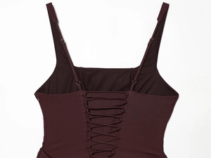 Detail of burgundy backless dress showing crisscross lace-up straps and knit fabric texture