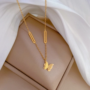 Detailed view of a gold butterfly necklace nestled in a soft beige jewelry gift box