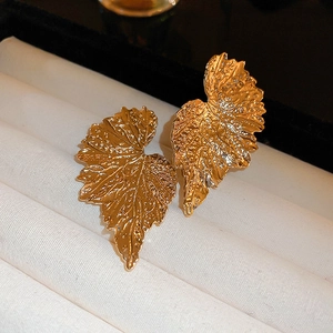 Elegant gold leaf earrings with textured veins displayed in a white jewelry gift box