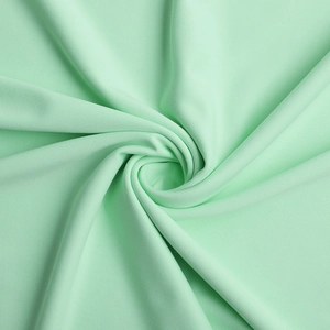 Vue détaillée de la texture du tissu vert menthe doux pour une robe de soirée chic