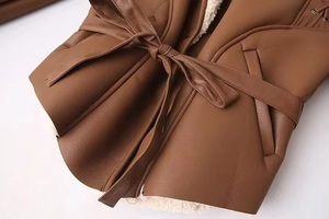 Détails d'une veste en similicuir marron avec doublure en fausse fourrure blanche