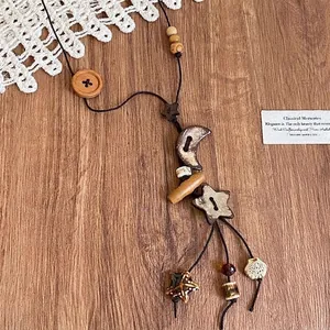 Detail of ethnic wooden necklace featuring star moon pendant and rustic button beads