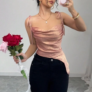 Détail de caraco rose scintillant avec col bénitier et ourlet asymétrique chic