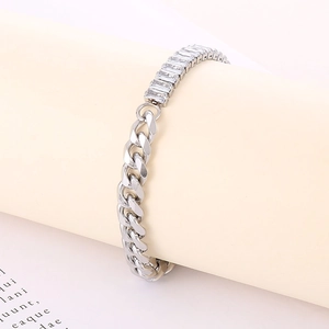 Close-up of silver Cuban link bracelet featuring a rectangular gemstone inlay on a stand