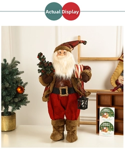 Detail of a standing Santa doll with plaid clothes holding a lantern and a mini Xmas tree