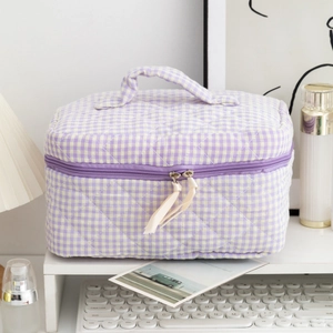 Detailed view of purple checkered quilted makeup bag with handle and ribbon zippers
