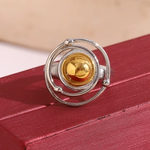 Macro detail of two-tone stainless steel Saturn ring with gold ball and silver ring