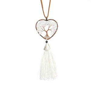 Macro shot of handmade heart tree of life crystal ornament with long white tassels