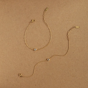 Détail de chaînes trombones et à billes en or avec zircon rond et poinçon K18